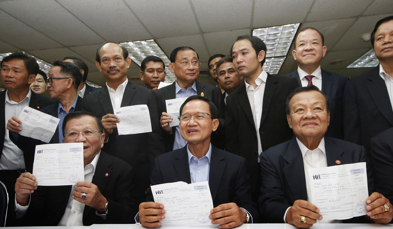 Thailand's former Prime Minister Somchai Wongsawat and former lawmakers show receipt after registering their memberships to Pheu Thai Party in Bangkok. Photo: AP
