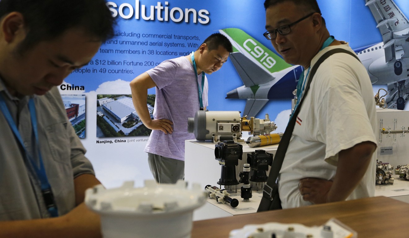 Visitors look at aircraft component parts on display at Aviation Expo China in Beijing. Photo: AP