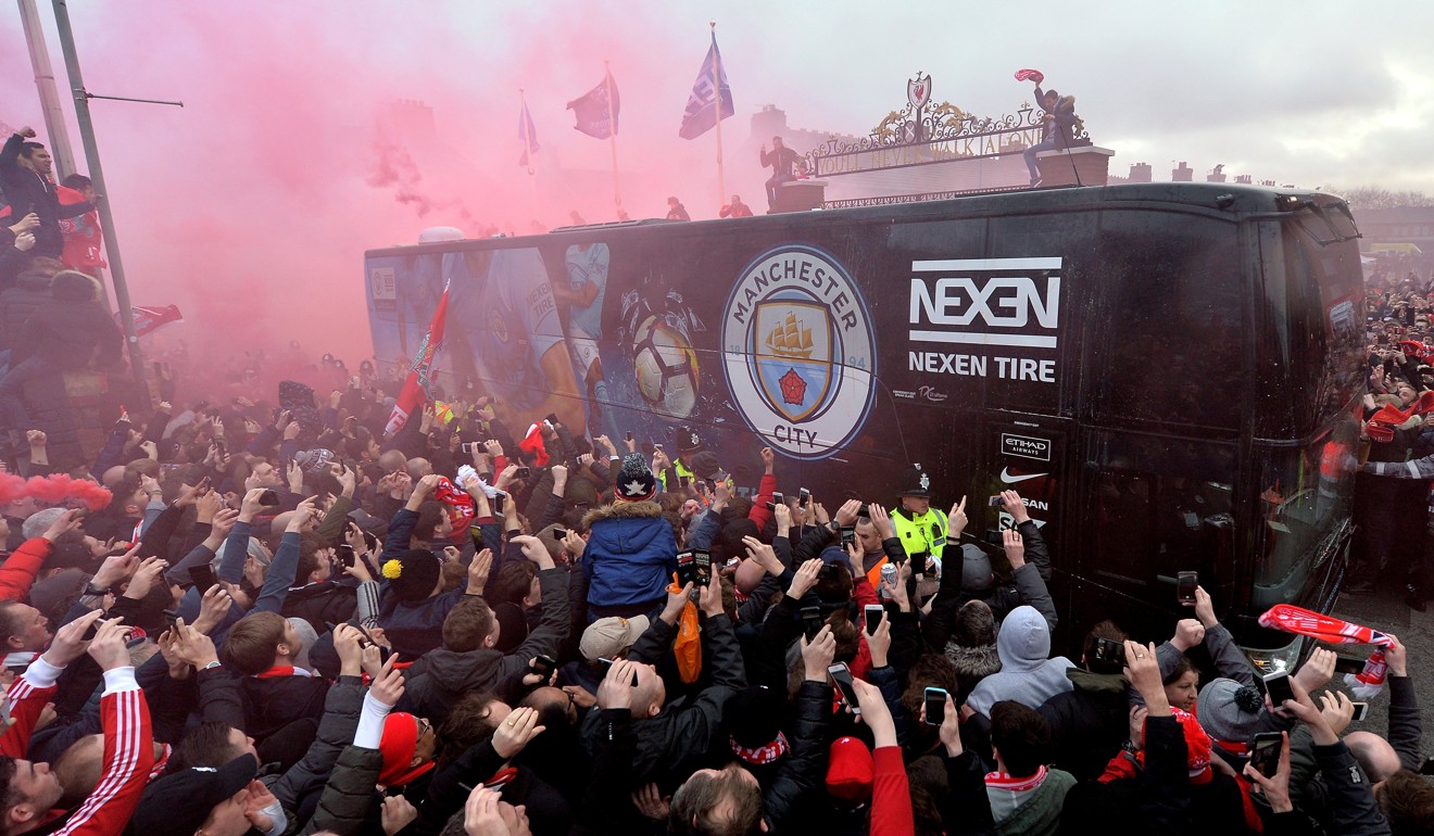 Liverpool supporters ignite red flares as the Man City team bus arrives. Photo: EPA