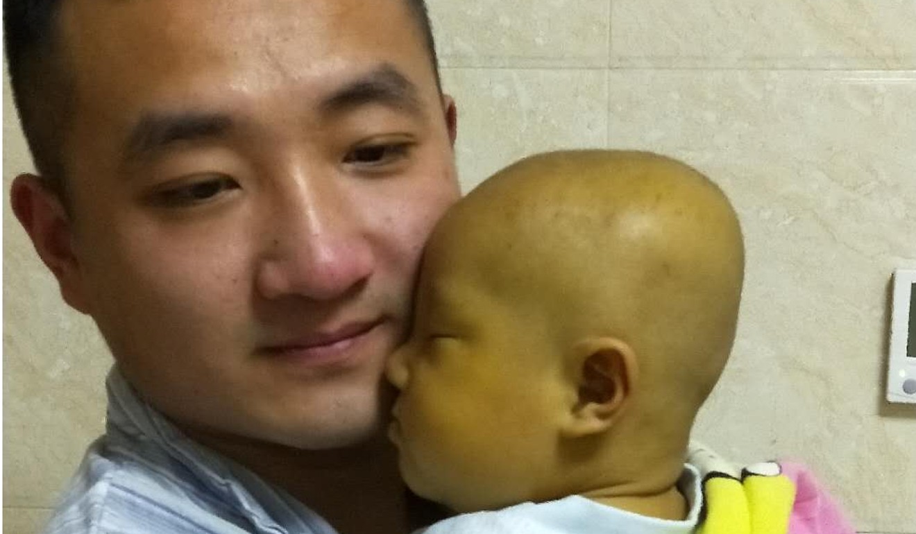 Du Xingzhou holds his infant son Du Yuze the night before the liver transplant. Photo: Du Xingzhou