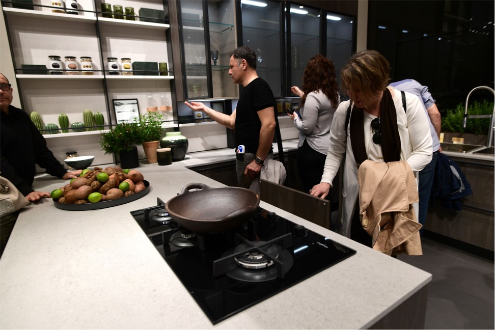 Visitors look at the kitchen fittings at the Veneta Cucine stand at the Salone del Mobile furniture fair in Milan. Photo: AFP