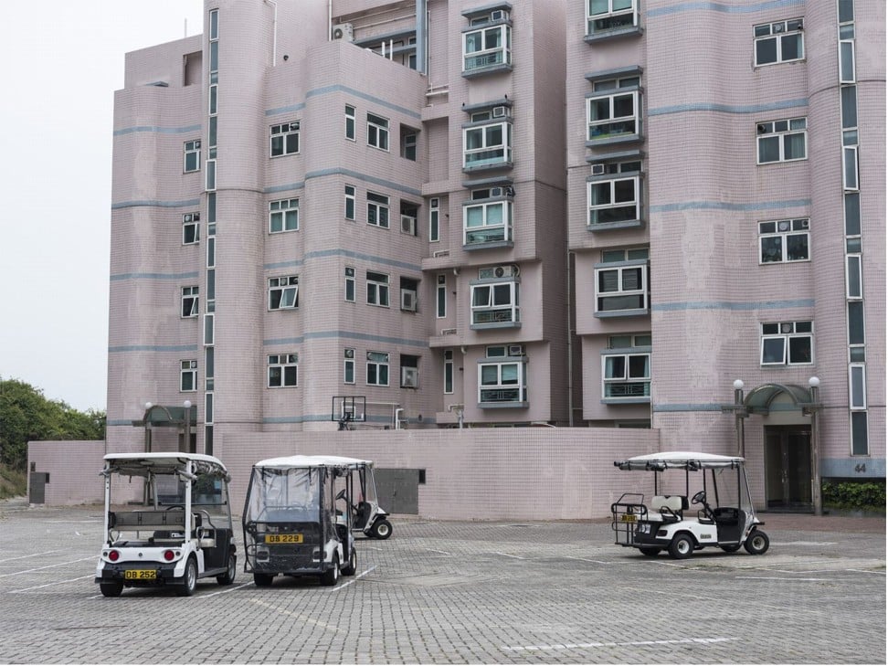 Golf carts sit parked in front of a residential building. Photo: Justin Chin/Bloomberg
