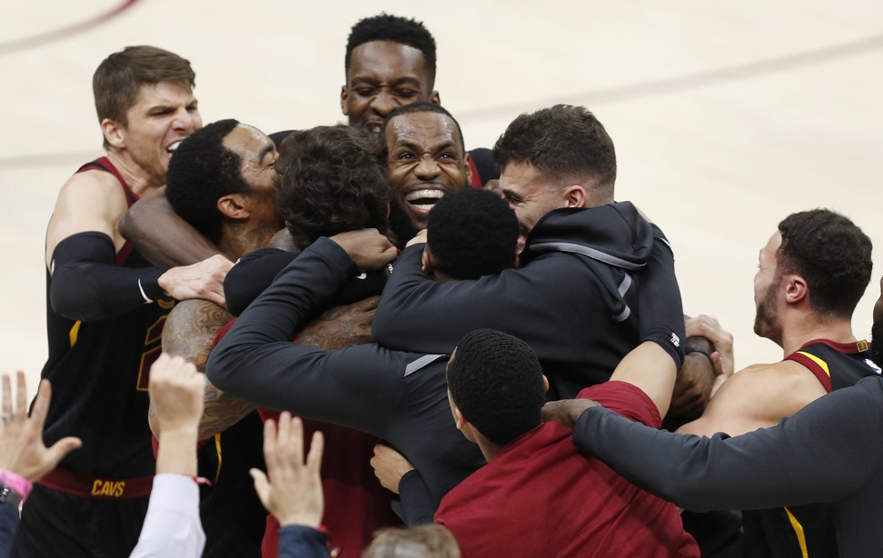 LeBron James is mobbed by his teammates after making the game-winning shot. Photo: EPA
