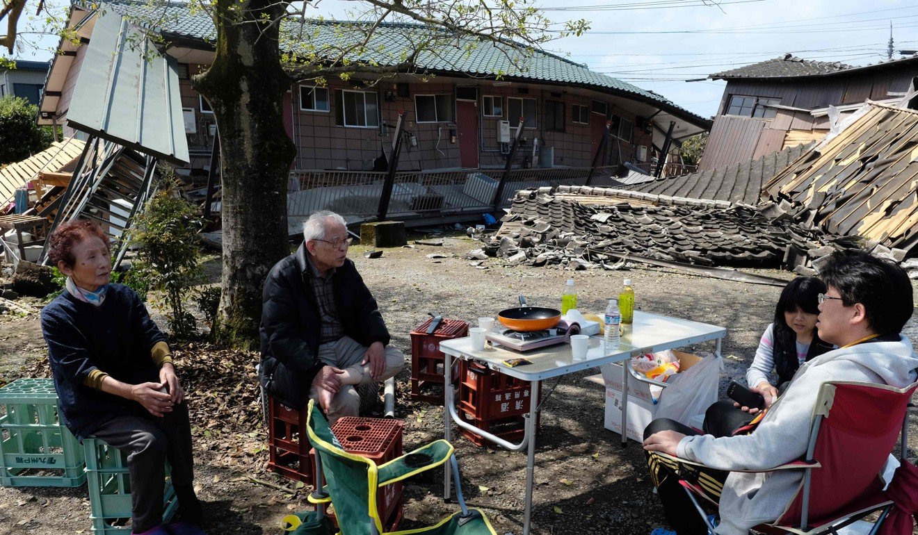 Residents in Kumamoto prefecture, Japan, rest outside houses that collapsed in an April 2016 earthquake, an example of the external threats that are thought to determine a society’s tightness. Picture: AFP