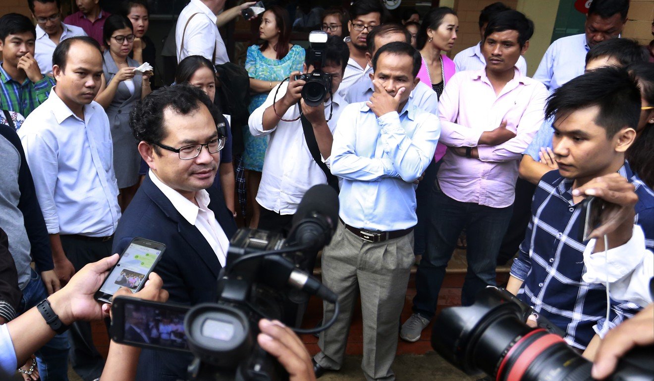 Kay Kimsong, left wearing glasses, editor-in-chief of the Phnom Penh Post, speaks to reporters after being fired. Photo: AP
