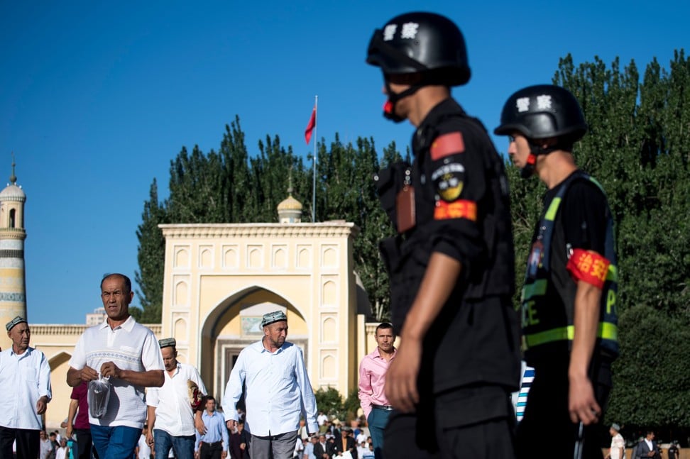 Police patrol as Uygur Muslims leave the Id Kah Mosque in Kashgar, Xinjiang after morning prayer. Photo: AFP