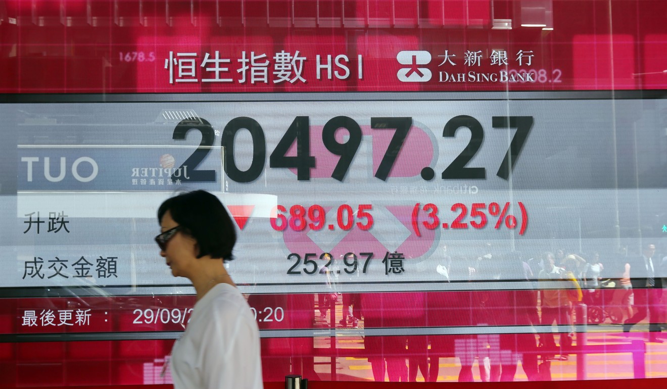 A woman walks past an electronic board displaying the Hang Seng Index in Central. In her new role at HKEX, Laura Cha is the only woman among the chairmen of Hong Kong’s 50 blue-chip firms. Photo: Sam Tsang