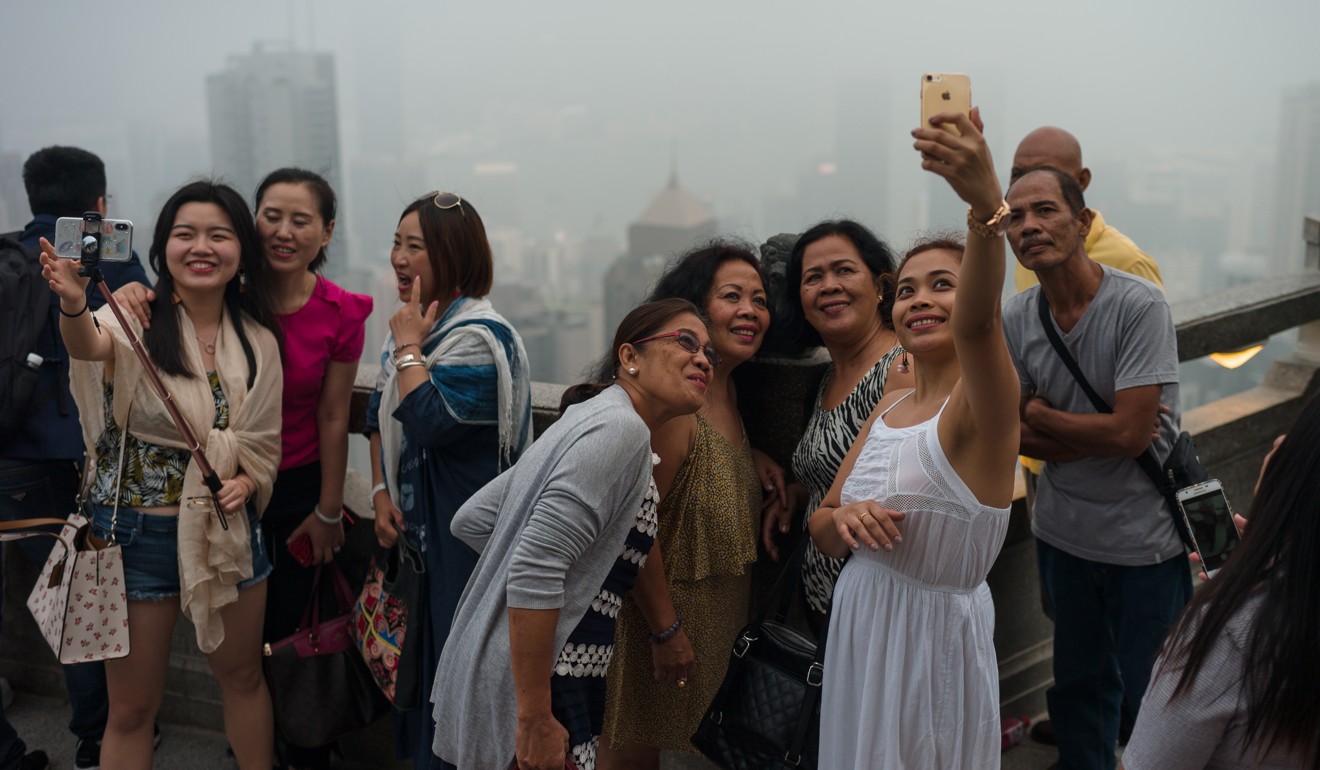 Visitors take photographs from a viewing pavilion on Victoria Peak in Hong Kong. The economy is booming, according to the latest economic data. Photo: EPA-EFE 