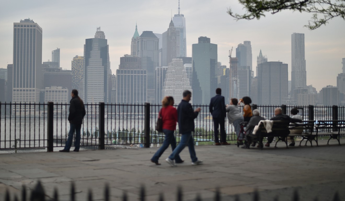 People walk on the Brooklyn Heights Promenade overlooking the Manhattan skyline in New York City. US household debt as a share of nominal GDP has declined and the cost of servicing that debt as a proportion of disposable income has fallen. Photo: AFP 