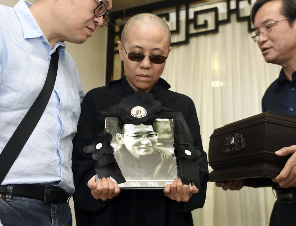Liu Xia holds a portrait of her late husband at his funeral in Shenyang, northeastern China’s Liaoning province, on July 15. Photo: AP