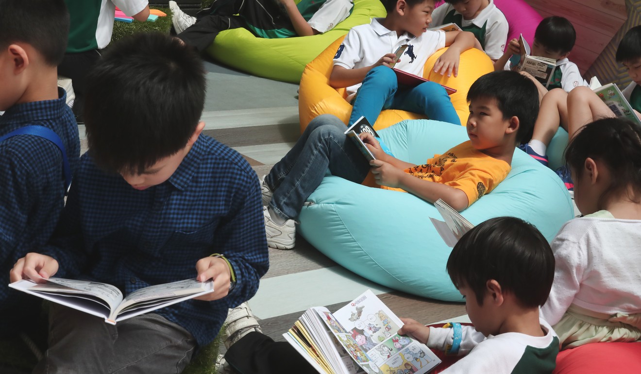 Children read at the Leisure and Cultural Services Department’s pop-up library event, as part of its World Book Day fest, at a school in Sham Shui Po on April 21. Photo: Jonathan Wong