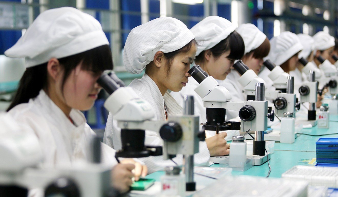 Women workers use microscopes to assemble micro motors for phones at a factory in Huaibei, Anhui province, China. Photo: EPA/WAN