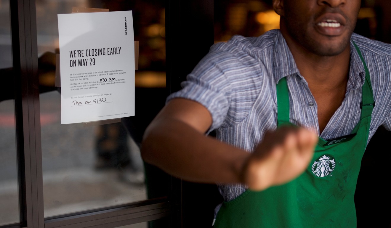 A Starbucks employee in Philadelphia reacts to media coverage beside a notice on the shop’s door saying ‘We're Closing Early on May 29.’ Photo: Reuters