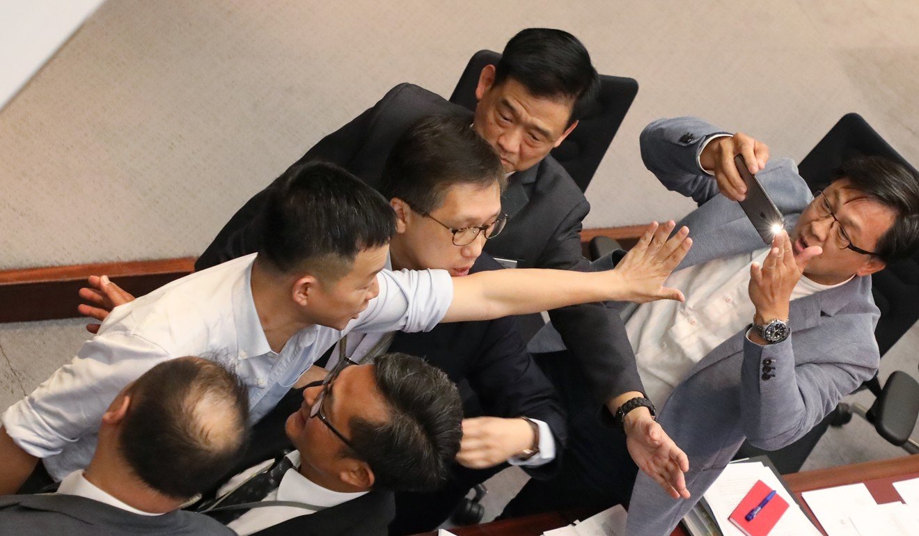 Lawmaker Junius Ho (right) records the goings-on in Legco. Photo: Edward Wong