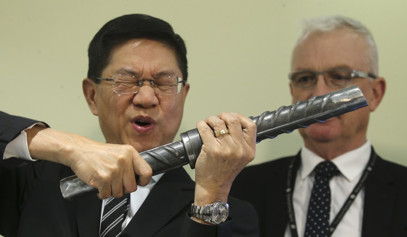 Philco Wong (left) demonstrates how a steel rebar is screwed into a coupler. Photo: Dickson Lee