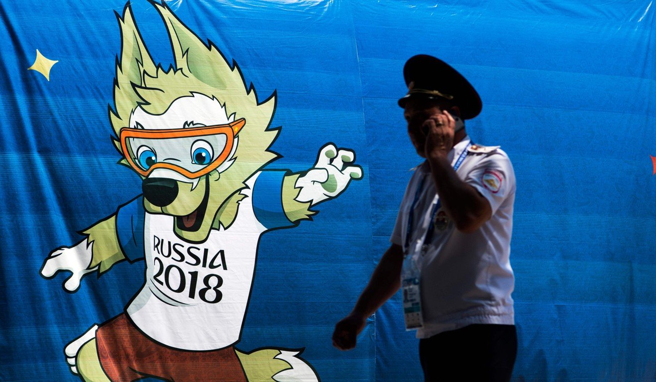 A police officer speaks on a mobile phone in front of a banner featuring Zabivaka, the official mascot of the upcoming 2018 Fifa World Cup, outside Olymp Stadium outside Gelendzhik, Russia, on Saturday. Photo: Agence France-Presse