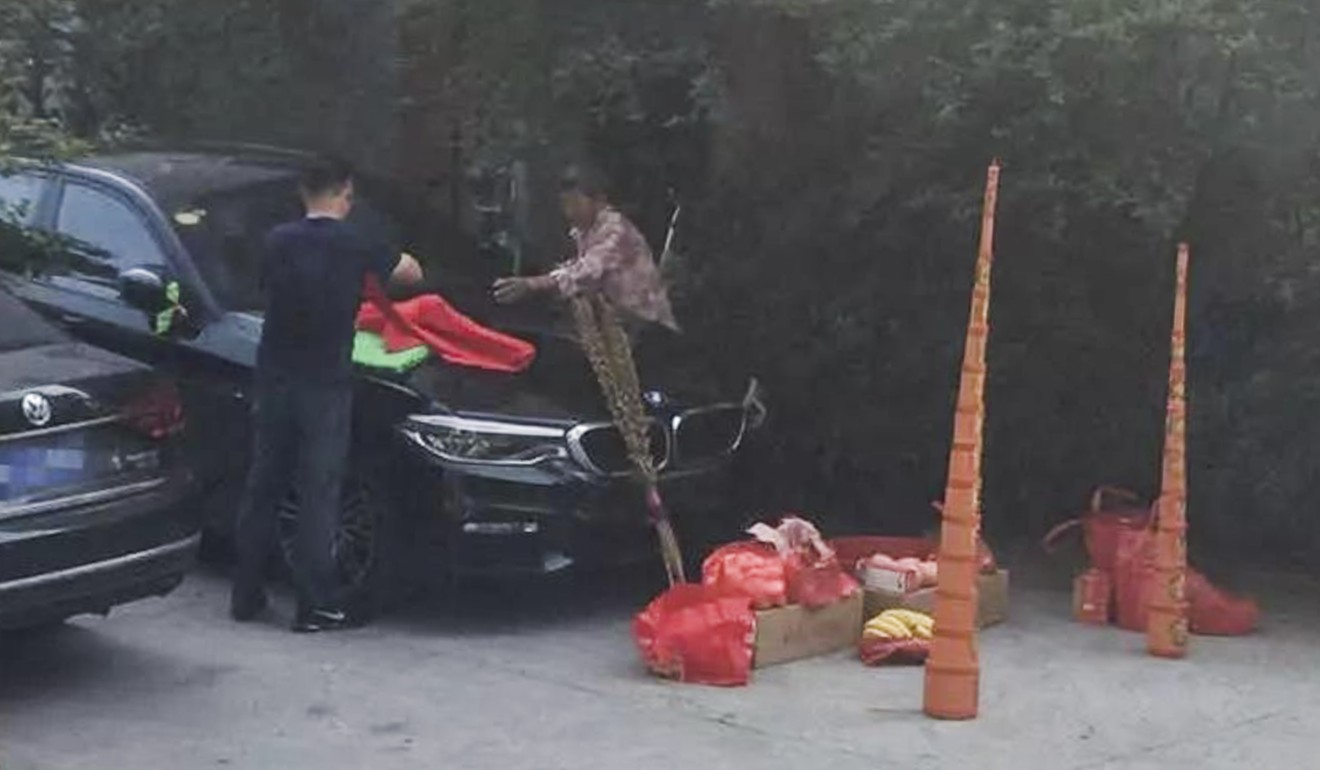 A man and a woman were photographed setting up large joss sticks by the car. Photo: sohu.com