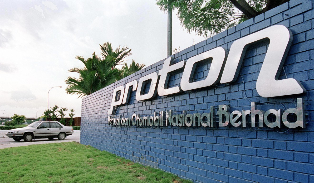 The first version of Malaysia's national car the Proton Saga passes the sign for the company’s plant in Shah Alam. Photo: AFP