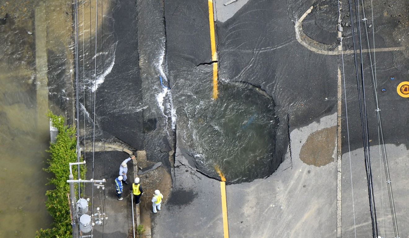 Water flows from cracks in a damaged road in Takatsuki, Osaka prefecture. Photo: Reuters