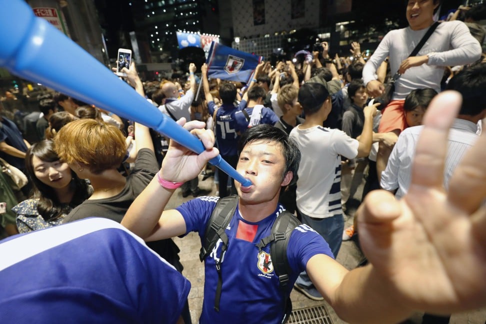 People celebrate Japan’s qualification for the World Cup round of 16 in Tokyo’s Shibuya entertainment district in the early hours. Photo: Kyodo