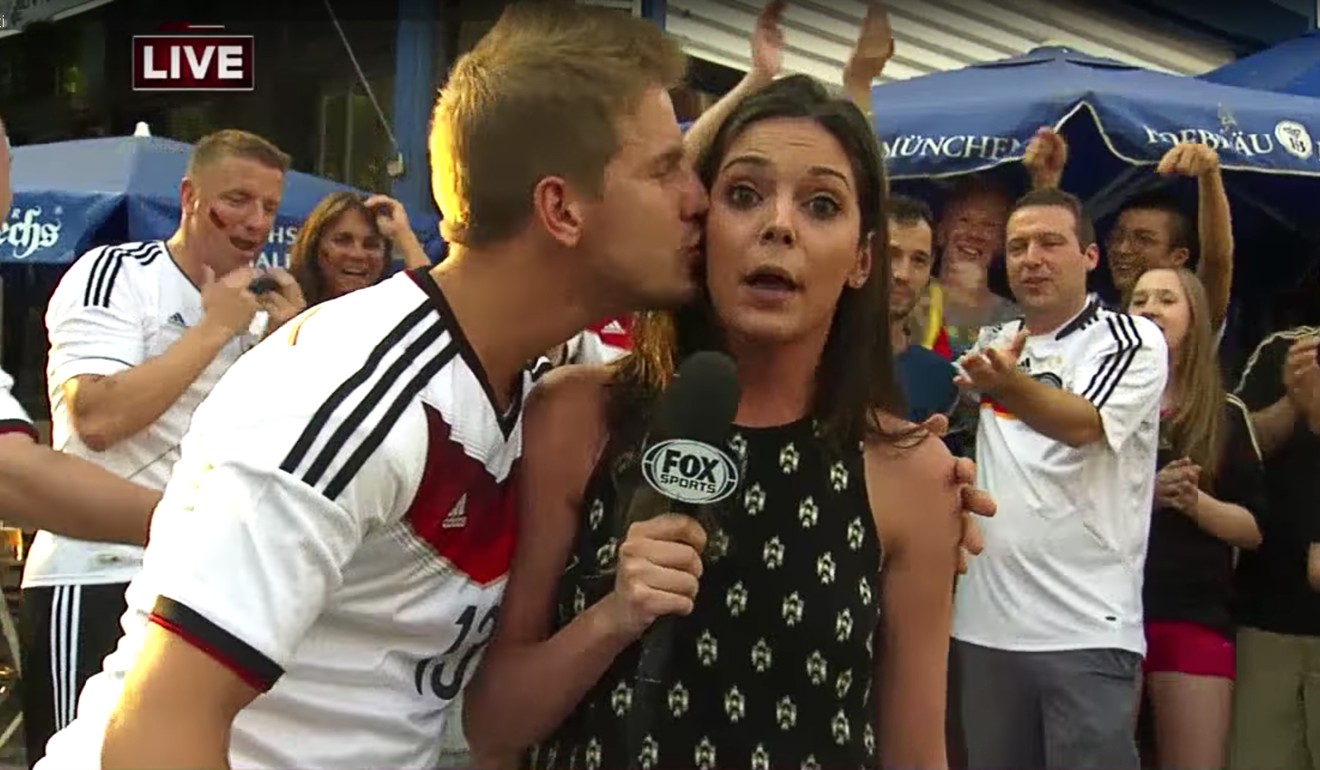 A German soccer fan plants a kiss on Fox Sports’ Katie Nolan after Germany’s win against Algeria in New York in June. Photo: YouTube / Fox Sports