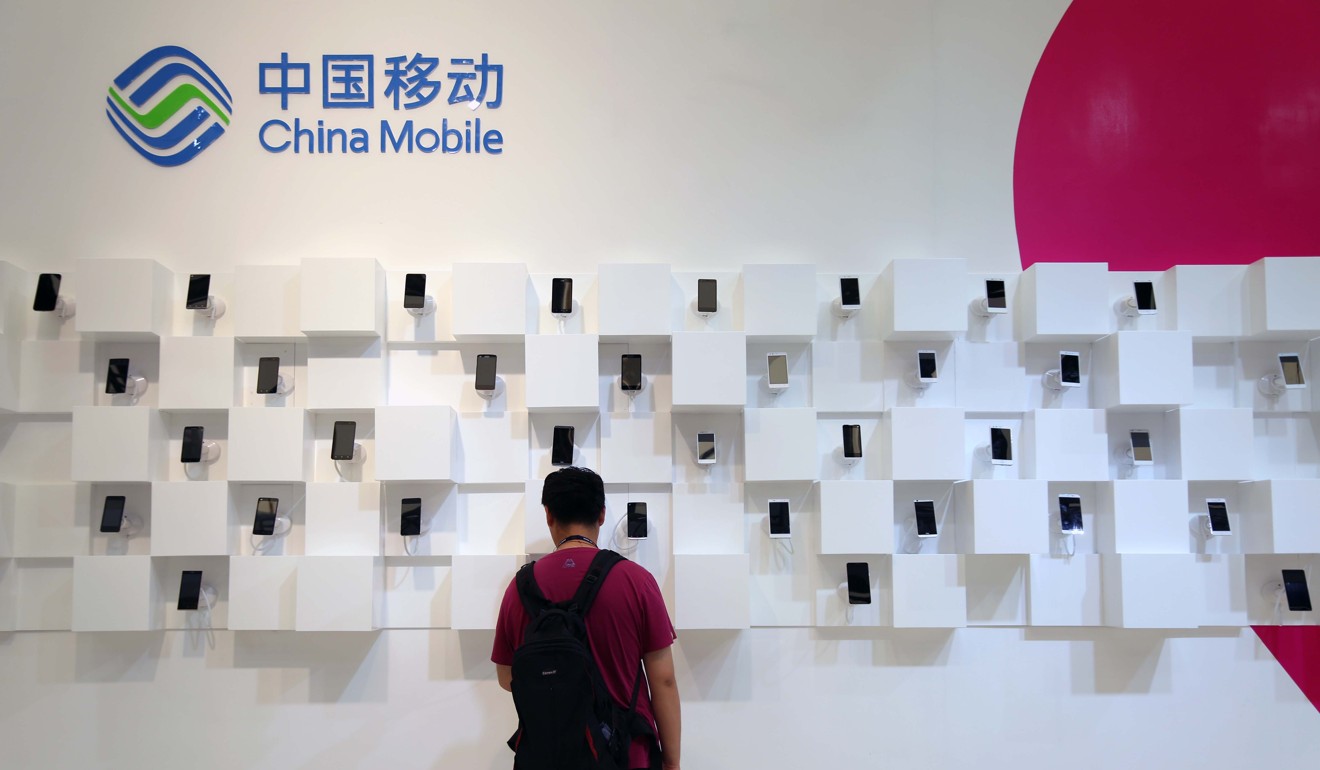A visitor is seen at the stand of China Mobile during an exhibition in Shanghai, China, July 16, 2015. Photo: Bloomberg