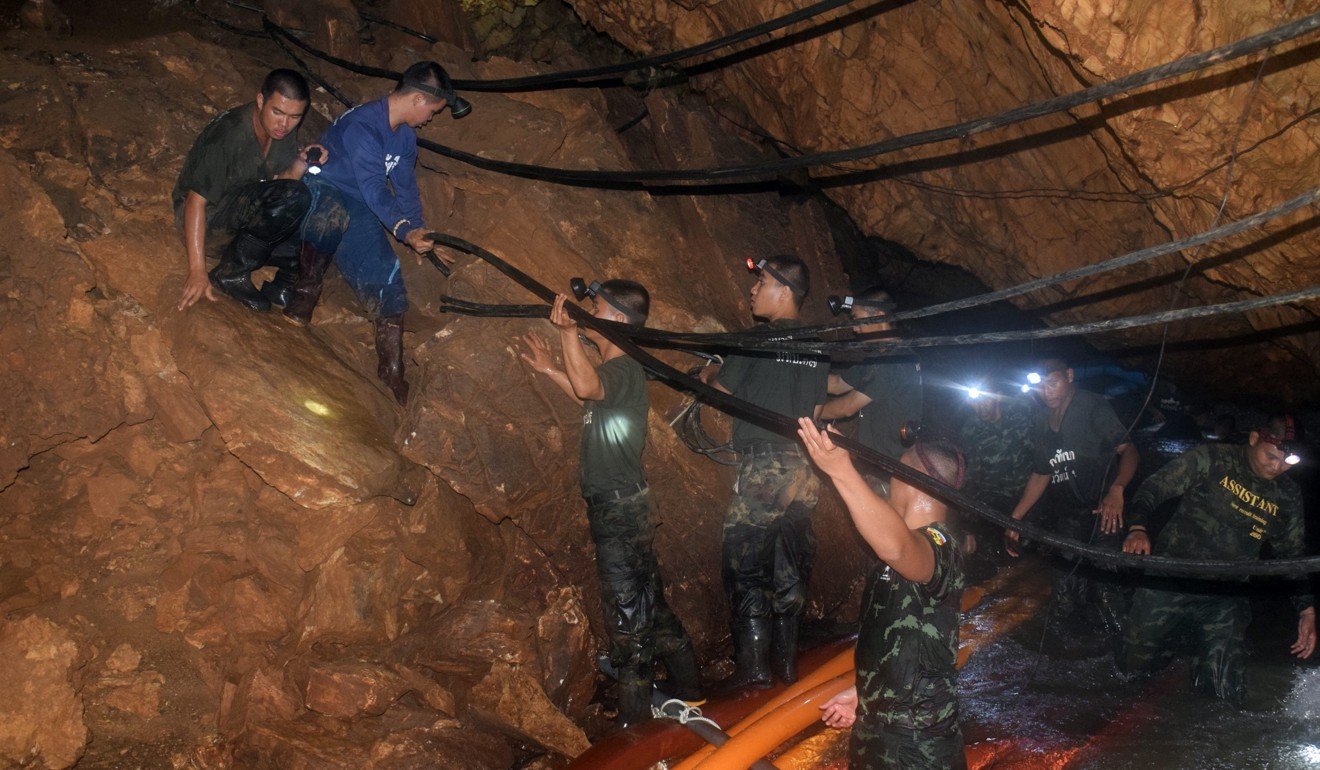 Thai soldiers pull cables through the cave complex during the rescue operation for a group of 12 young soccer players and their coach at Tham Luang cave in Khun Nam Nang Non Forest Park. Photo: EPA