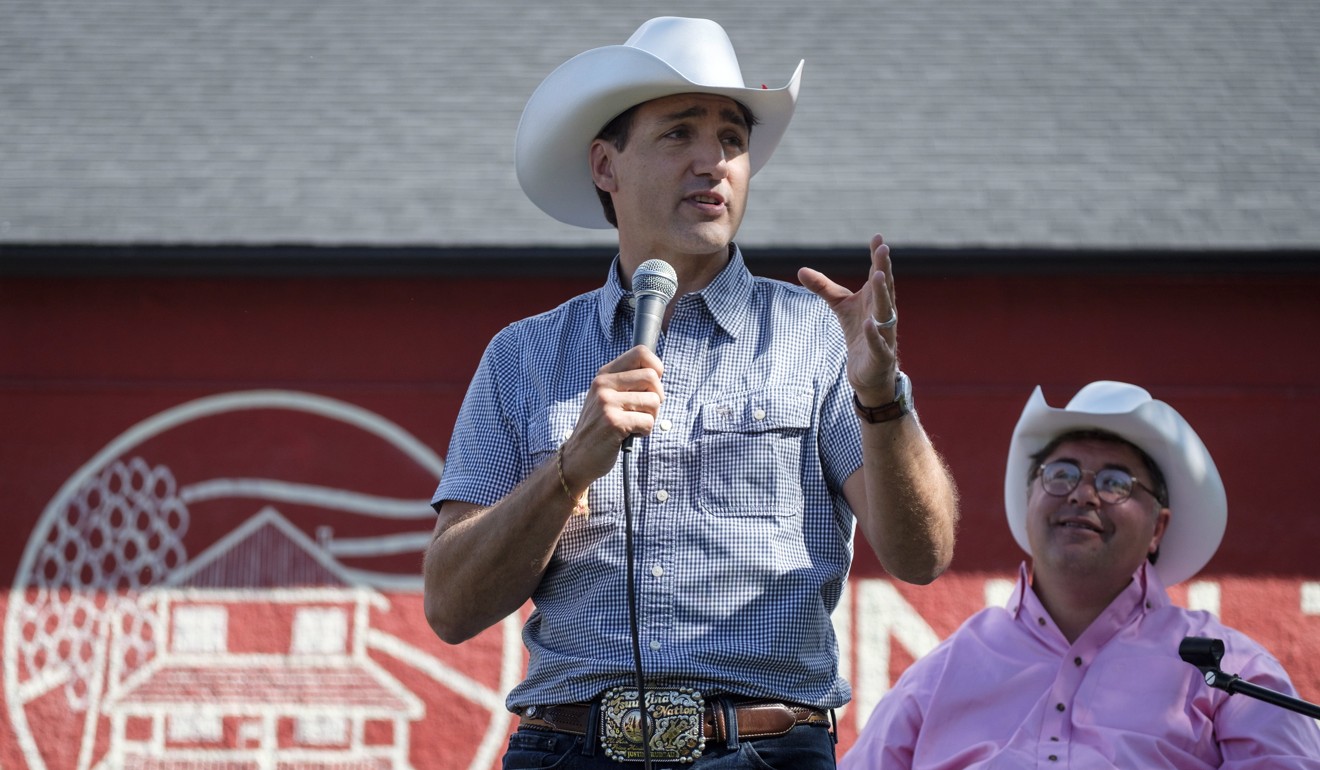 Prime Minister Justin Trudeau, left, delivers remarks as MP Kent Hehr looks on as he attends a pancake breakfast in Calgary on Saturday. Photo: The Canadian Press via AP