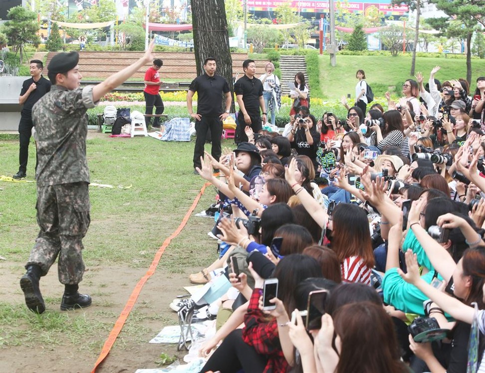 K-pop star Ryeowook waves to about 400 waiting fans as he is discharged from the army on Tuesday. Photo: Yonhap