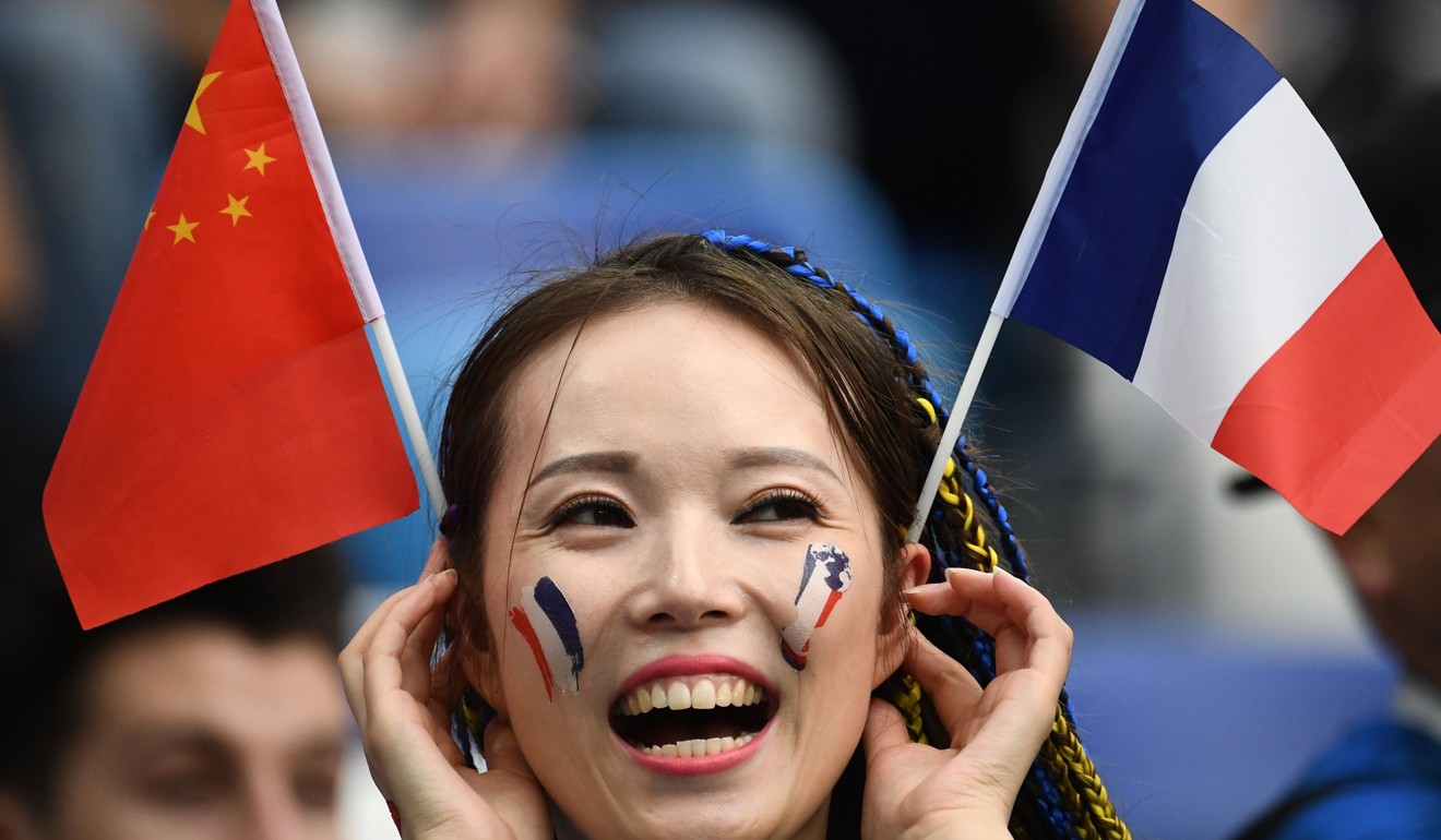 A France fan with Chinese and French flags cheers before the quarter-final against Uruguay at the Nizhny Novgorod Stadium. Photo: AFP