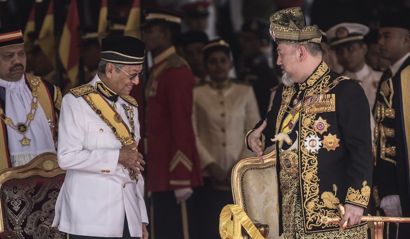 The king speaks with Prime Minister Mahathir Mohamad during the ceremony. Photo: AFP
