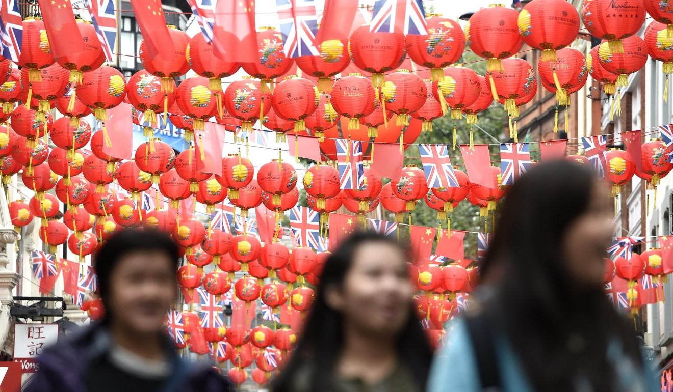Visitors walk under lanterns and Chinese and British flags in Chinatown, central London. Photo: EPA