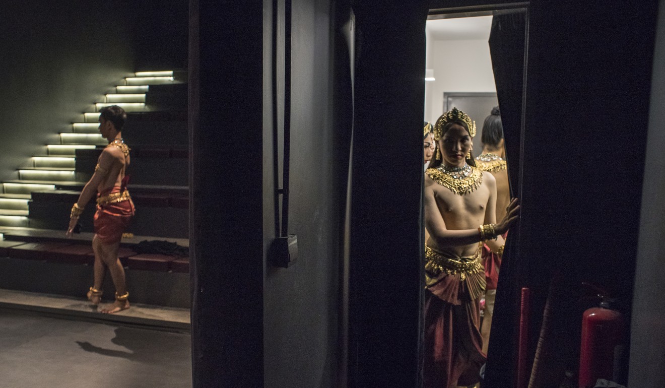 Pichoudom Phun warms up onstage (left) as fellow dancer Sokhon Tes leaves a small room backstage and others apply the final touches to their make-up before a performance. Photo: Enric Catala