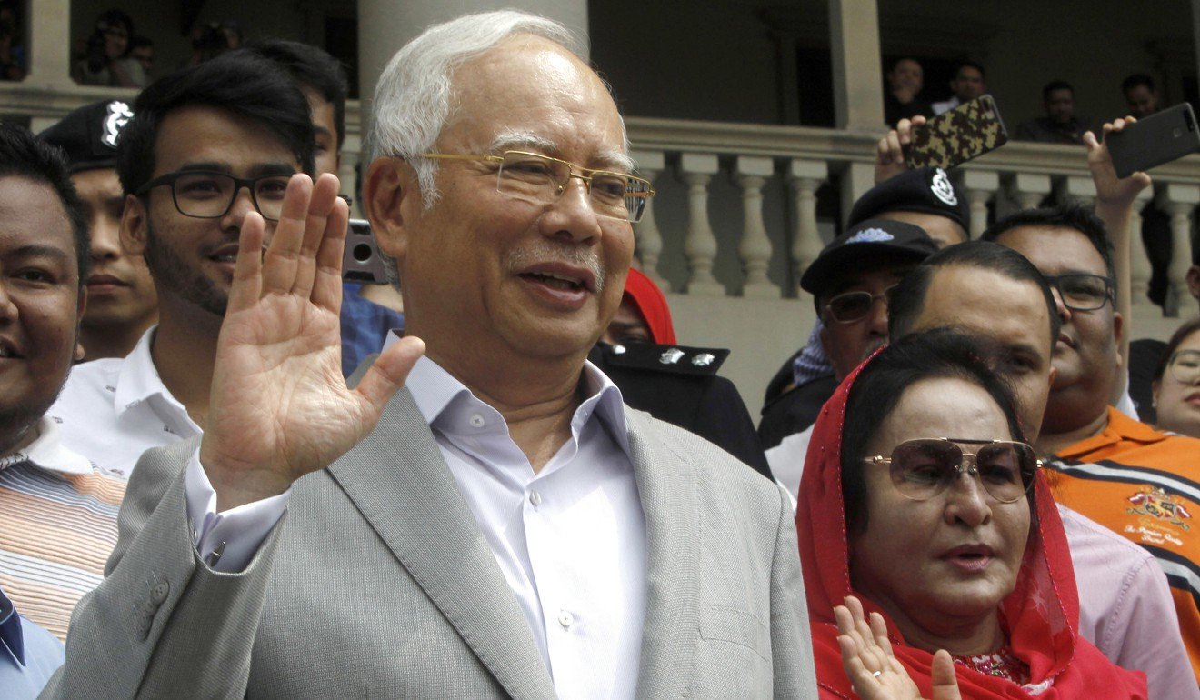 Former Malaysian Prime Minister Najib Razak and his wife Rosmah Mansor wave to supporters as they leave the High Court in Kuala Lumpur on July 9. Najib was charged with criminal breach of trust and corruption, two months after a multibillion-dollar corruption scandal at a state investment fund led to his stunning election defeat. Photo: AP