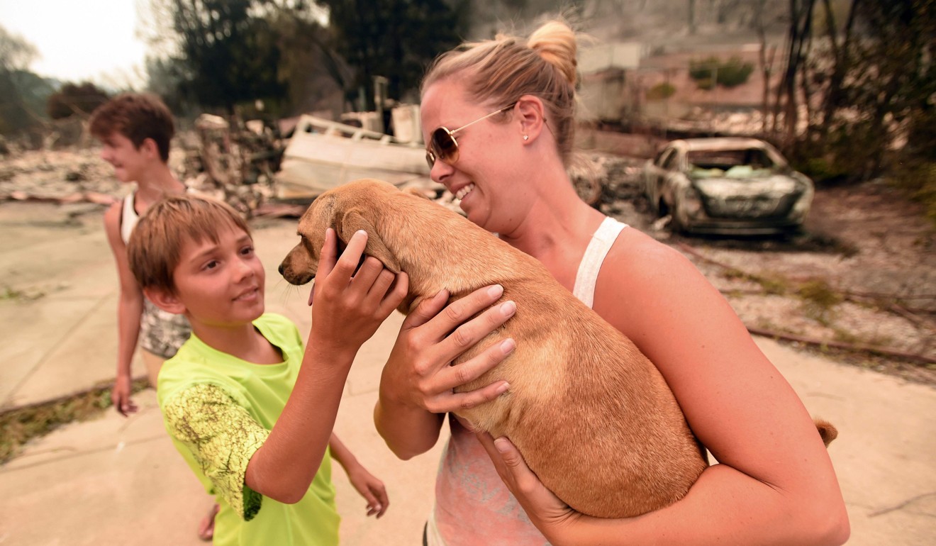 Keela Brilz holds her dog Zoe who was returned safely to her at her burned home in Redding, California on July 27, 2018. Photo: AFP