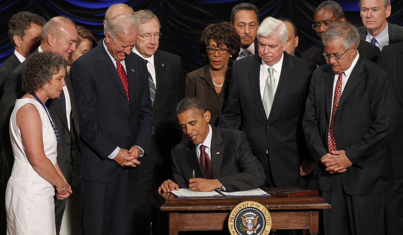 US President Barack Obama signs the Dodd-Frank Wall Street Reform and Consumer Protection bill in July 2010. Representative Mel Watt is seen in the rear, sixth from right. Photo: AP