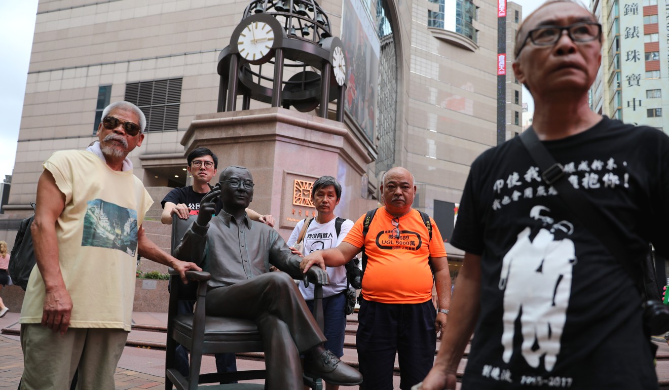 Activists, including Avery Ng (second from left) and “the Bull” Tsang Kin-shing (second from right), prepare to move Liu’s statue from Times Square to Paterson Street. Picture: Sam Tsang