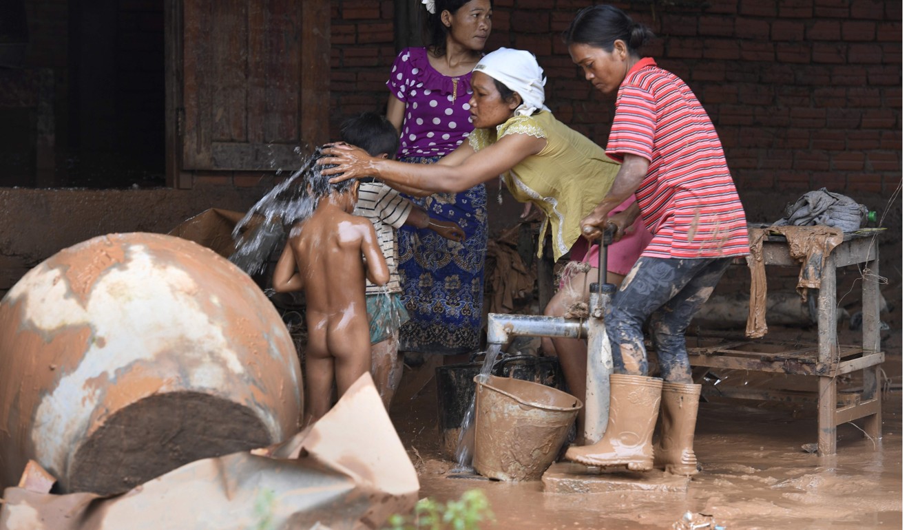 A woman bathes children in Attapeu province, Laos, after torrential floods. Photo: AFP