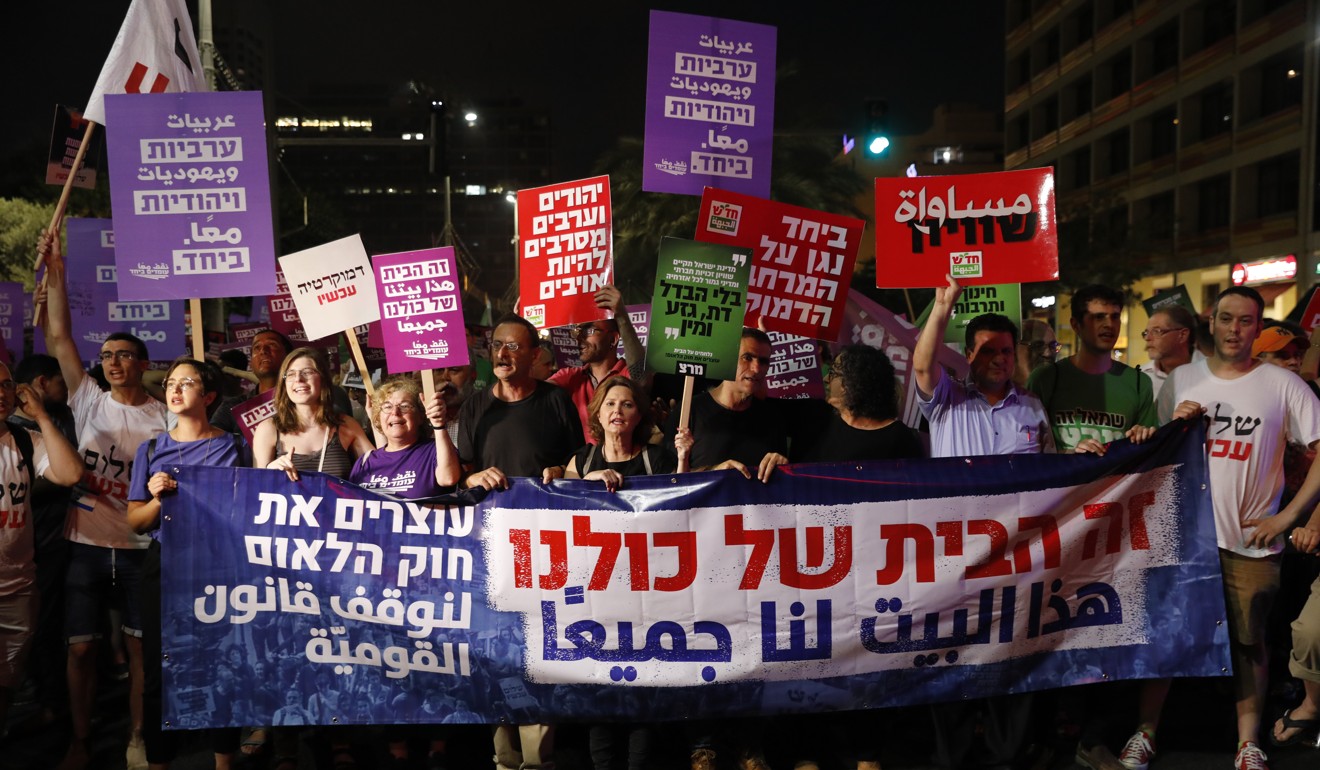 Israelis hold placards reading “This house belongs to all of us” during a protest against the controversial “nationality bill”, in Tel Aviv on July 14. Photo: EPA