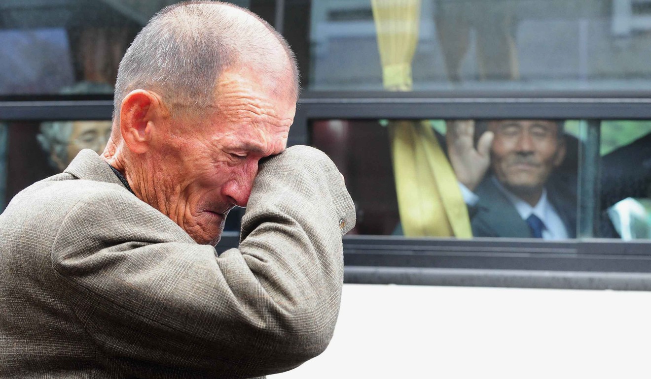 A South Korean old man wipes his tears as a North Korean relative (on the bus) waves goodbye after a reunion in 2010. File photo: AFP
