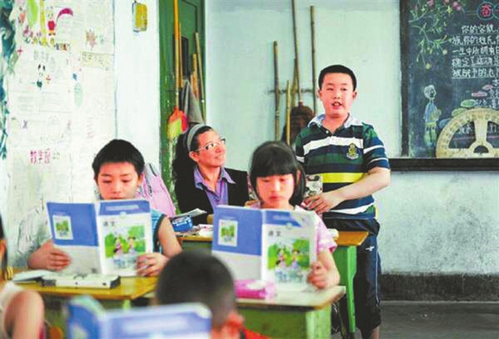 Pang Zhihua gave up her job so she could sit beside her son, Bao Han, in class and help him with his studies. Photo: Handout