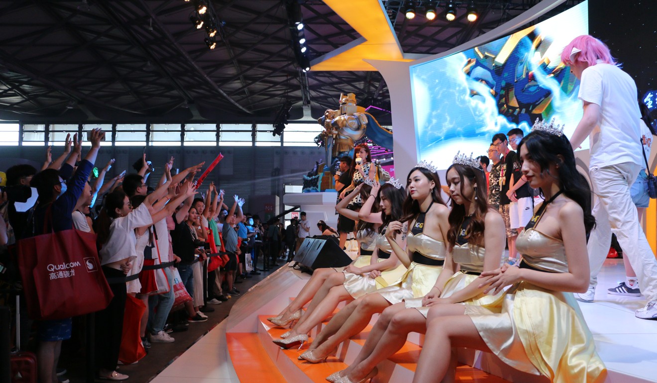 Showgirls interact with the audience at the booth of mobile games developer IGN. Photo: Zheping Huang