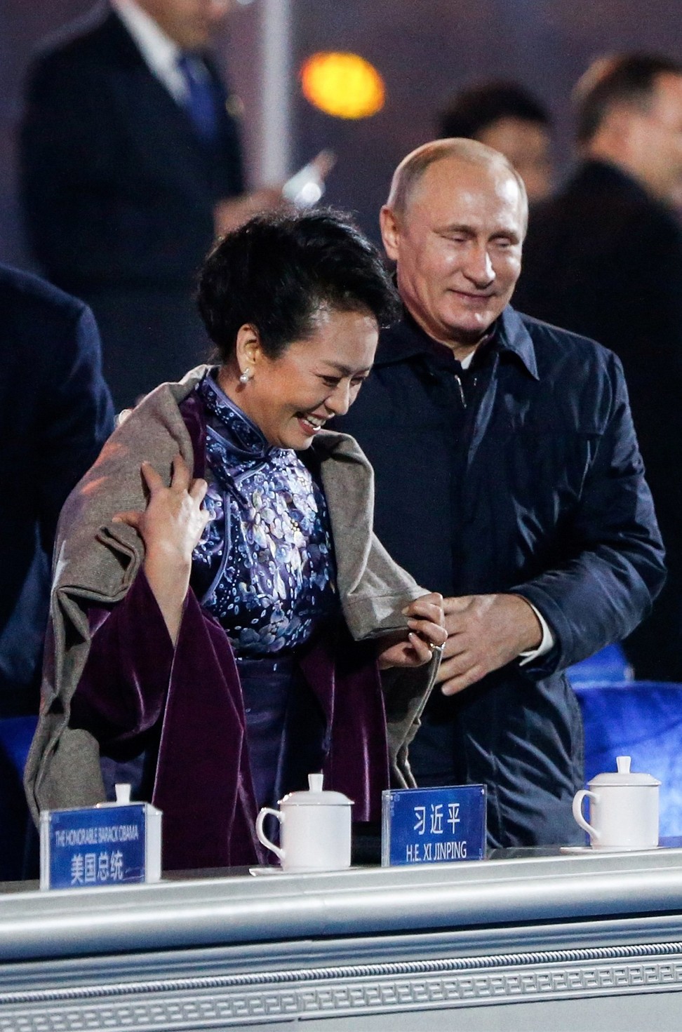 Russia’s President Vladimir Putin (right) helps put a shawl on Peng Liyuan, wife of China’s President Xi Jinping, as they watch a lights and fireworks at the opening of the Apec summit at a Beijing stadium in November 2014. Photo: Reuters