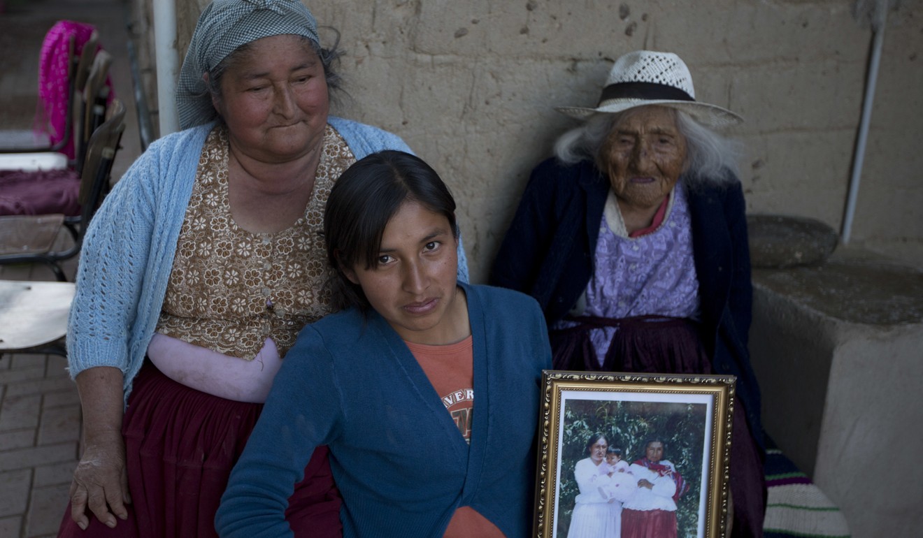 In this August 23, 2018 photo, 117-year-old Julia Flores Colque Julia Flores Colque, behind right, poses for a photo with her grandniece Agustina Berna, left, and her great-grandniece Rosa Lucas at their home in Sacaba, Bolivia. Photo: AP