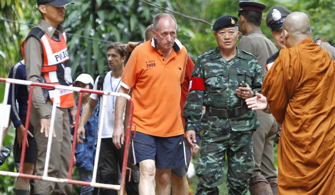 British cave diver Vernon Unsworth walks next to a Thai soldier and policemen during the rescue operations for the youth soccer team and their coach at the Tham Luang cave in Thailand June 30. Photo: EPA-EFE