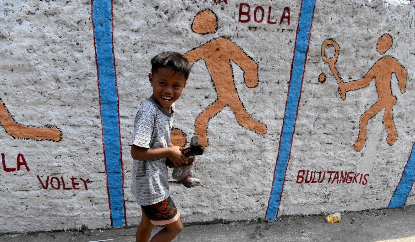 An Indonesian boy plays with his pigeons in the neighbourhood where Dedy Sukma lived. Photo: AFP