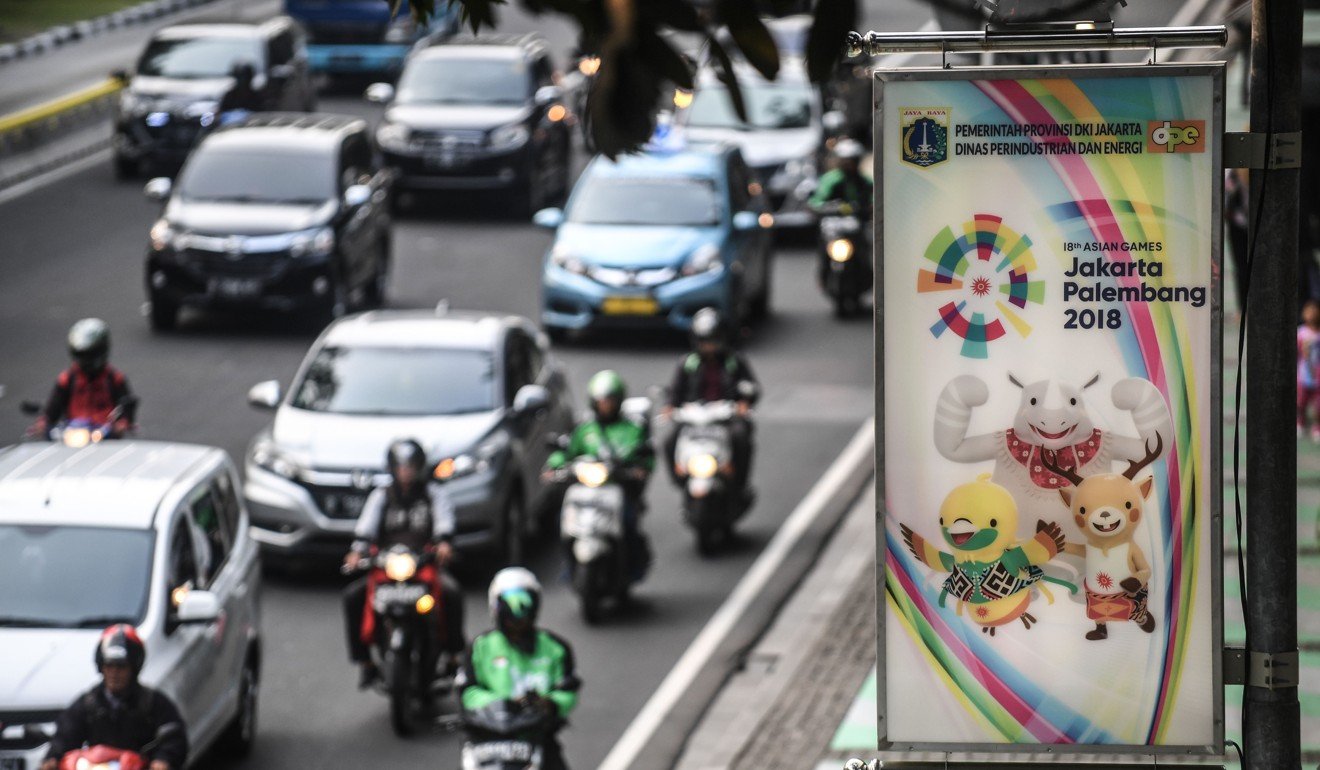 Motorists pass by an Asian Games hoarding. Photo: Xinhua