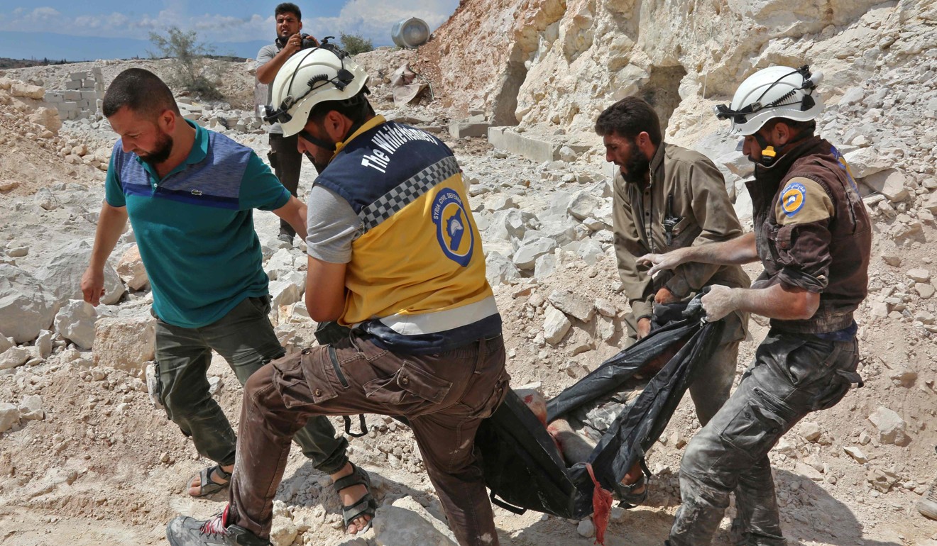Members of the Syrian Civil Defence, also known as the ‘White Helmets’, carrying a victim of air strikes in the southern countryside of Idlib province. Photo: AFP