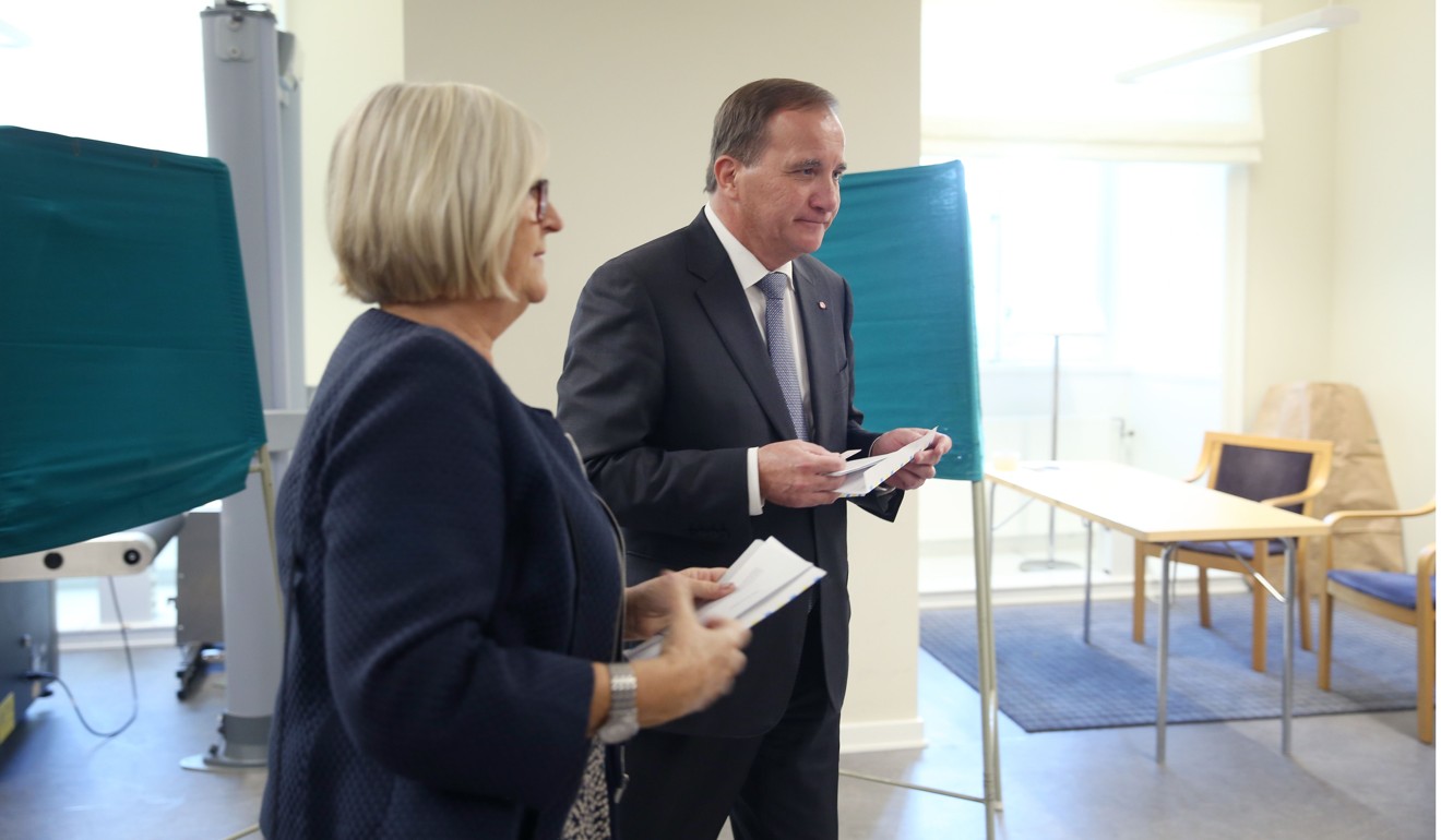 Lofven and his wife inside the polling station. Photo: AFP