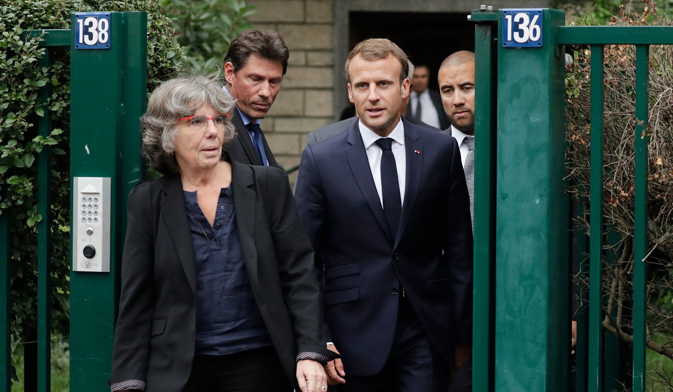 French President Emmanuel Macron walks next to Michele Audin, daughter of the late Maurice Audin, as he leaves the home of Josette Audin, widow of Audin, on Thursday in Bagnolet. Photo: Agence France-Presse